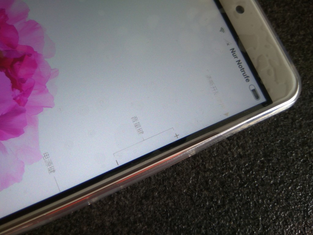 Hier ist das Mi Max in das transparente Schutzkondom für 1,81 Euro gepackt. Das Gerät wird dadurch nicht merklich größer aber viel handlicher weil rutschfester. Die "Billighülle" ist natürlich kein Kracher, aber erfüllt ihren Zweck prima. Bei den Tasten des Phablets (unten im Bild) wölbt sich die Schützhülle ein wenig drüber. Das sieht nicht "perfekt" aus aber ist in der Praxis schnuppe.