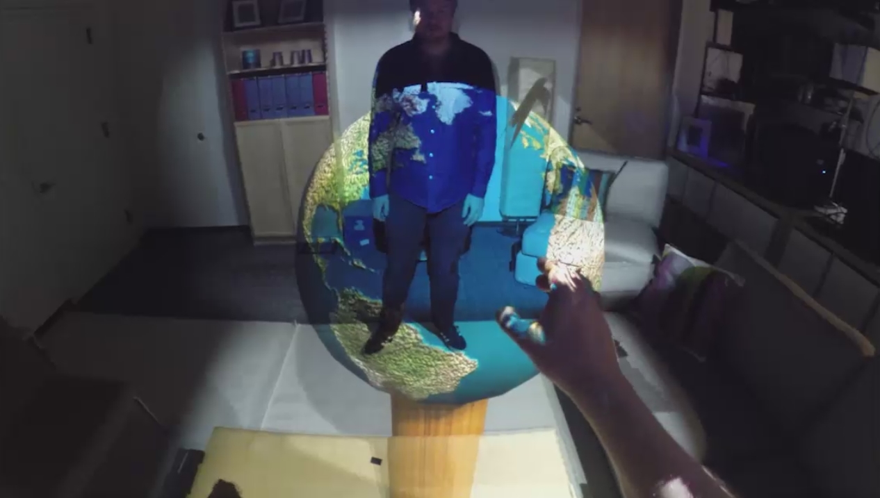 Die holografische Weltkugel schwebt im Raum und lässt sich interaktiv bewegen. Beide Personen sehen die Kugel jeweils mit eigener Ansicht. (Foto: Microsoft)